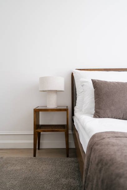 istock White hotel room with comfortable bed close to bedside table with reading lamp 2164110268