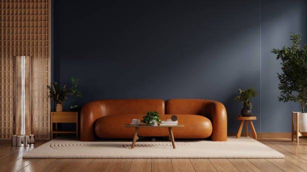 Living room features a sophisticated design with a rich dark blue accent wall, complemented by a stylish orange leather sofa- 3D rendering