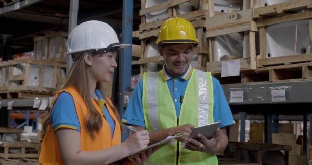istock Warehouse management team using computer laptop check stock inventory. Asian men women worker use software computer type keyboard goods shelf. Teamwork logistics staff counting stock store inventory 2164125838