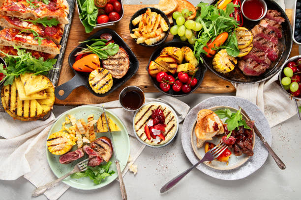 istock Table with grilled food. Pizza, corn, tomatoes, peppers, cooked meat. BBQ time 2164129222