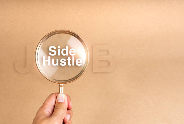 istock Side jobs, finding second work and searching extra income concepts. Text Side Hustle in gold magnifying glass in person's hand on brown recycled paper background with copy space. Business success. 2164130698