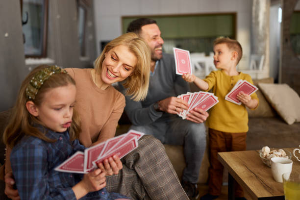 istock Happy family playing cards on sofa at home. 2164134930
