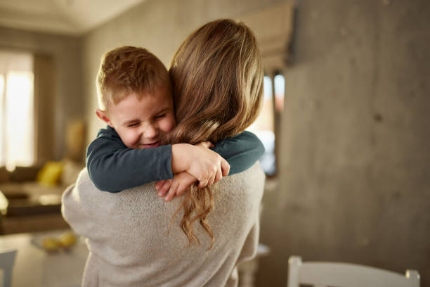 istock Loving son embracing his mother in dining room. 2164135262