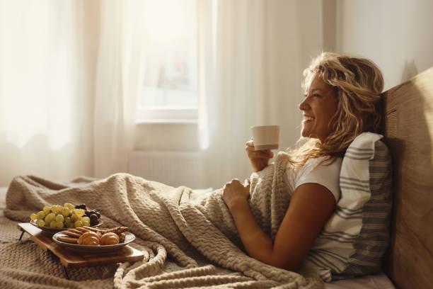 istock Happy woman relaxing during morning in a bed. 2164135957