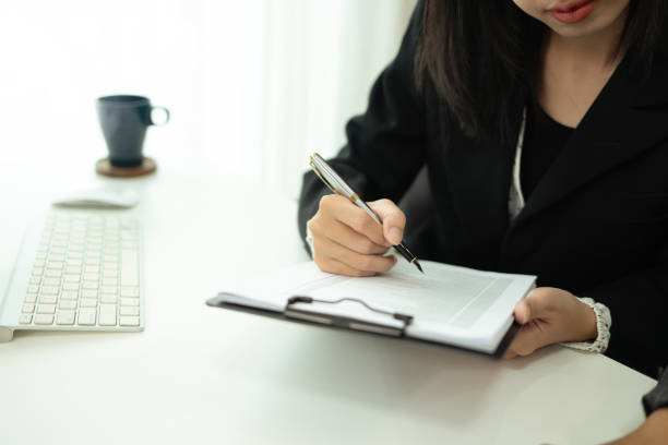 istock Smiling asian female employee examining documents at her workplace 2164136843