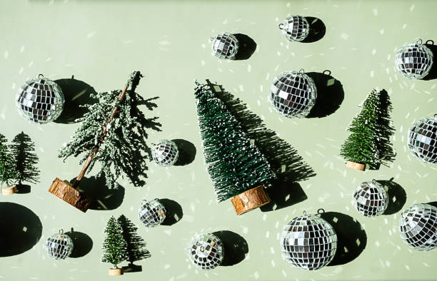 istock Green background with artificial Christmas trees and many shiny disco balls. 2164139344