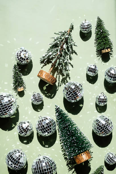 istock Green background with artificial Christmas trees and many shiny disco balls. 2164139350