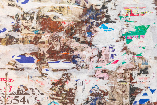 Old city street billboard with torn posters and stickers. Scratched placards and advertisements.