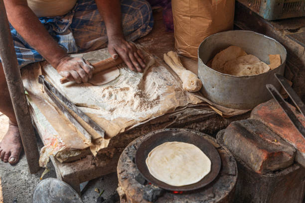 istock India, West Bengal, Kolkata, Bow Bazaar. Man rolling dough to make naan (bread). 2164139441