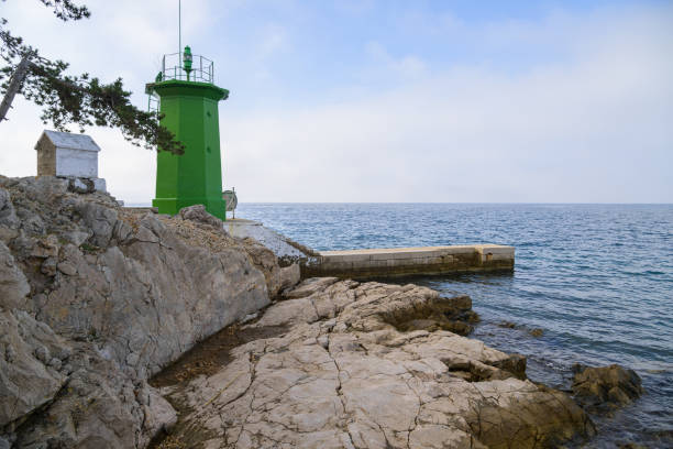 Manavgat harbour entrance and lighthouse with man fishing, bad weather