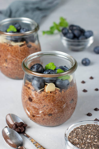 istock Healthy food: Chocolate chia pudding with blueberry and almonds in glass jars on gray background 2164140617