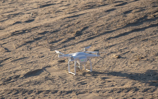 A small drone stands on the sand, new photography technologies