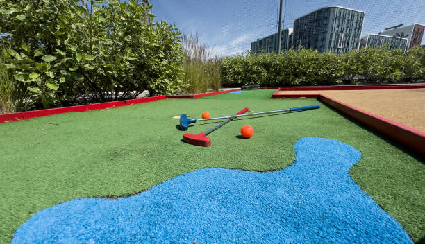 Golf stick and ball on green grass close up.