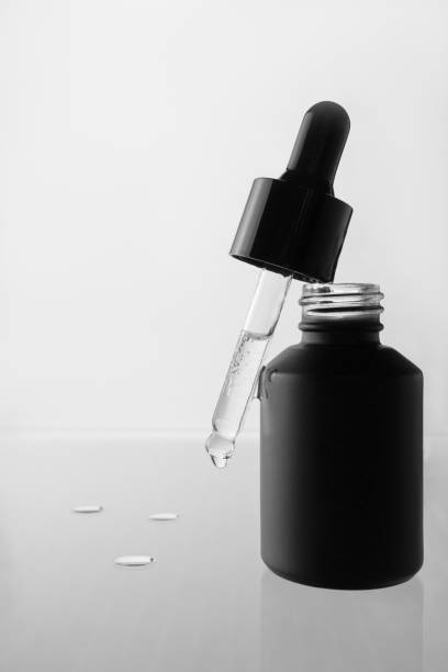 istock Cosmetic pipette with oil on a light background, reflected from the surface 2164141547