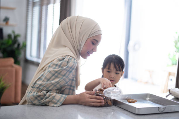 istock A mother and daughter spending time together in a modern kitchen while preparing cookies, with natural light streaming through the window blinds 2164141829