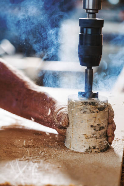istock Carpenter drilling hole in wood with power drill in workshop 2164142340