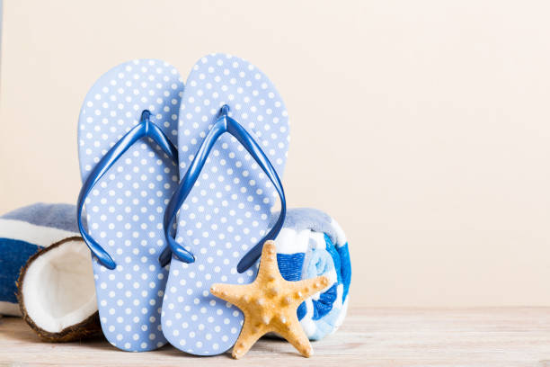 istock Top view composition of flip flops placed with beach accessories perspective view on table background. Tropical summer vacation concept Flat lay 2164147437