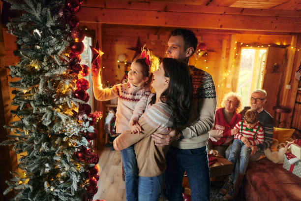 istock Happy family decorating Christmas tree at home. 2164150109