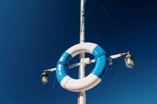 White and blue lifebuoy hanging on a pole with lanterns against the sky. High quality photo