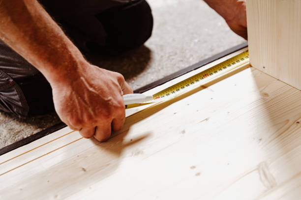 istock Carpenter taking measurement using tape measure on wooden plank 2164153091