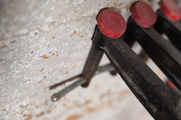 Clamps hold wood pieces together for gluing or drying, focusing on tools and woodworking techniques
