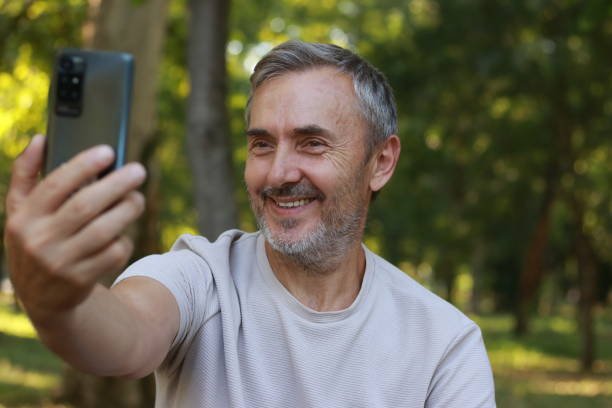 istock Modern mature man using phone for video call 2164153907
