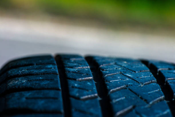 A detailed macro photo capturing the intricate texture and tread pattern of a car tire, showcasing its durable design and engineering.