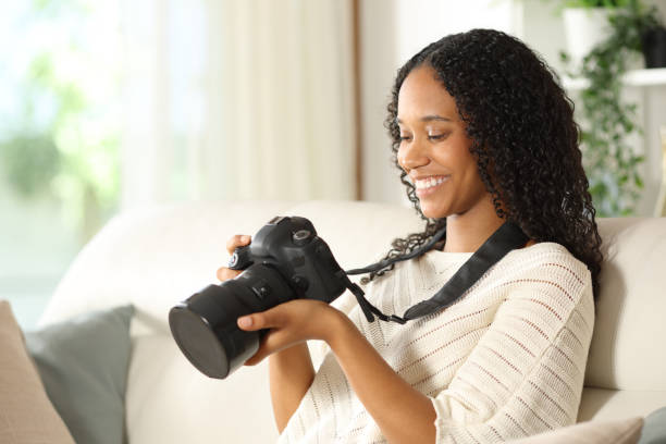 istock Happy black photographer checking camera at home 2164155835