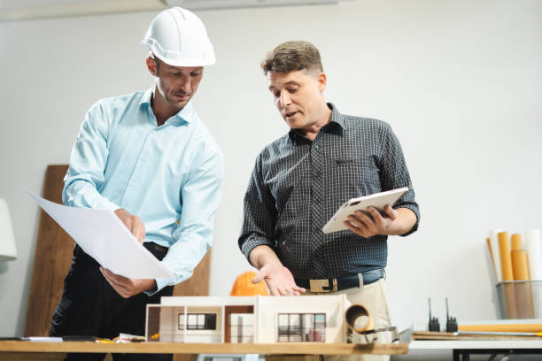 istock Architecture and teamwork concept. Male engineers or business partners on a construction site, discussing project details. 2164158832