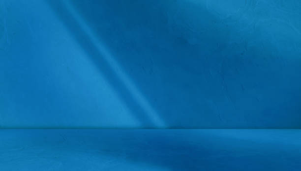 blue background studio room with light beam from above for product display especially cosmetic or beauty products. floor and wall backdrop muslin design backdrop. stone surface texture podium.