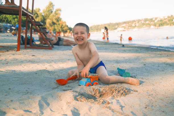 Boy playing with sand on beach