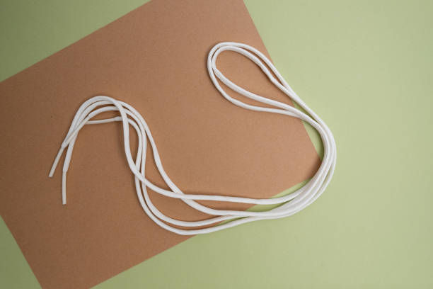 istock White shoe lace on a colored background. Shoe accessory 2164162418