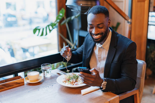 istock Businessman enjoying meal while using his phone. 2164166335