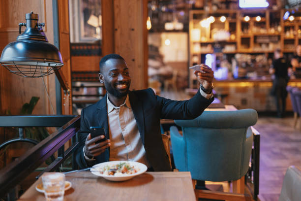 istock Man signaling for bill while dining at restaurant. 2164166569