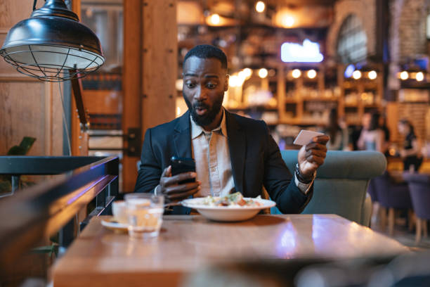 istock Man reacting to phone while dining at restaurant. 2164166611