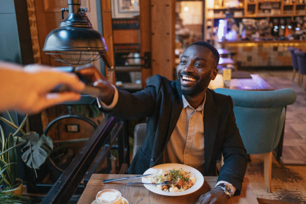 istock Cheerful man paying at modern restaurant table 2164166687