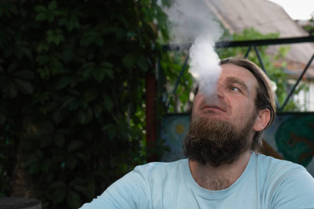 istock A man smokes an electronic cigarette and blows white thick smoke from his mouth 2164167569