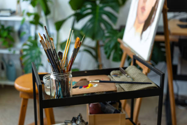 istock Paintbrushes and color palettes in a professional painting studio 2164168480