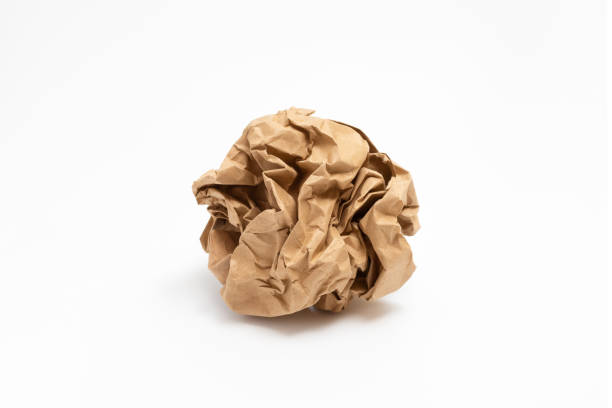 Crumpled paper isolated on white background. Worn brown paper.