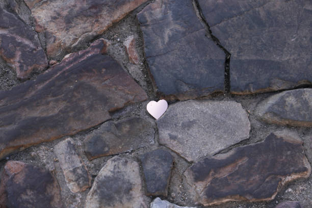 Silver paper heart on cobblestone floor in Spain