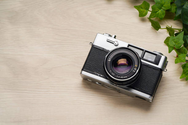 istock Old film camera isolated on wooden table 2164182029