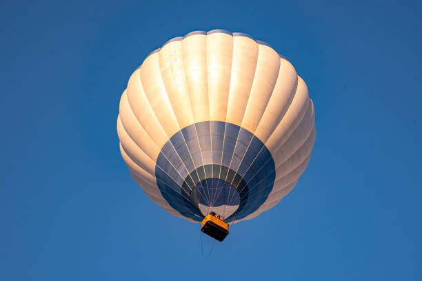 Igualada, spain - july 8, 2023: colorful hot air balloons and a paramotor soaring through the blue sky during the european balloon festival in igualada