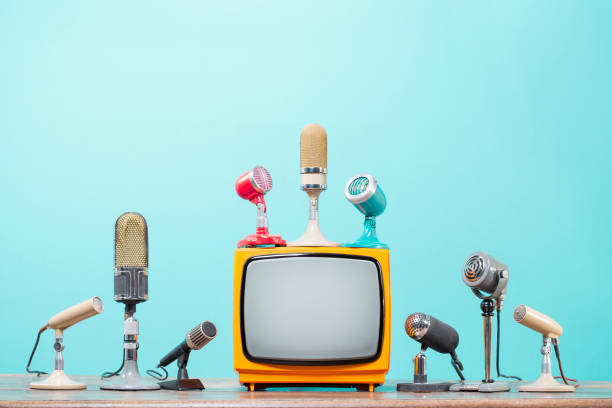 istock Retro microphones for press conference or interview and old TV on table front gradient aquamarine background. Vintage style filtered photo 2164185097