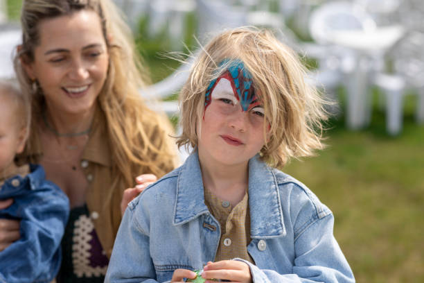little lovely girl waiting for rainbow face painting to be done
