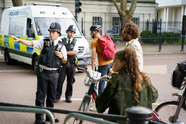 Police officers helping helping people with bicycles stock photo