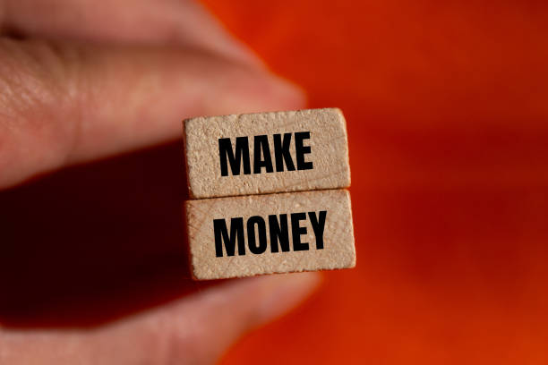 istock Make money message written on wooden blocks with orange background 2164189279