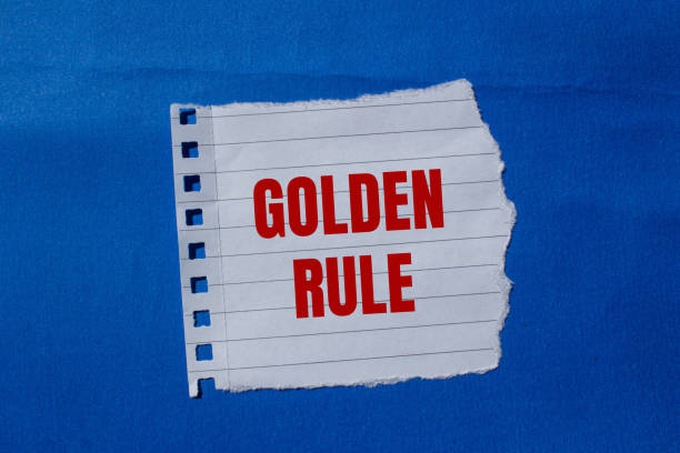 istock Golden rule message written on ripped torn paper piece with blue background 2164189589