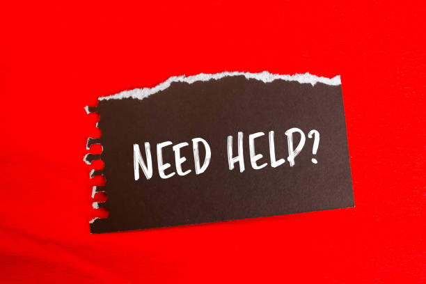Need help question message written on ripped torn black paper piece with red background. Conceptual need help question symbol. Copy space.