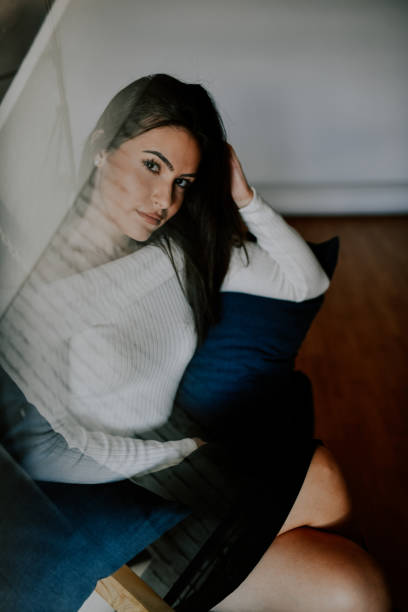 istock Female Showing Her Seductive Gaze While Sitting At Home 2164192206