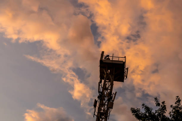 istock Signal tower or cell phone tower against the sky with white clouds 2164198727